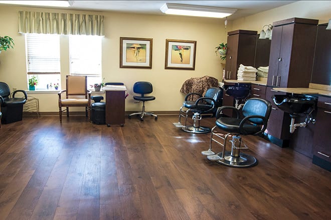 A cozy salon interior featuring barber chairs and an office desk.