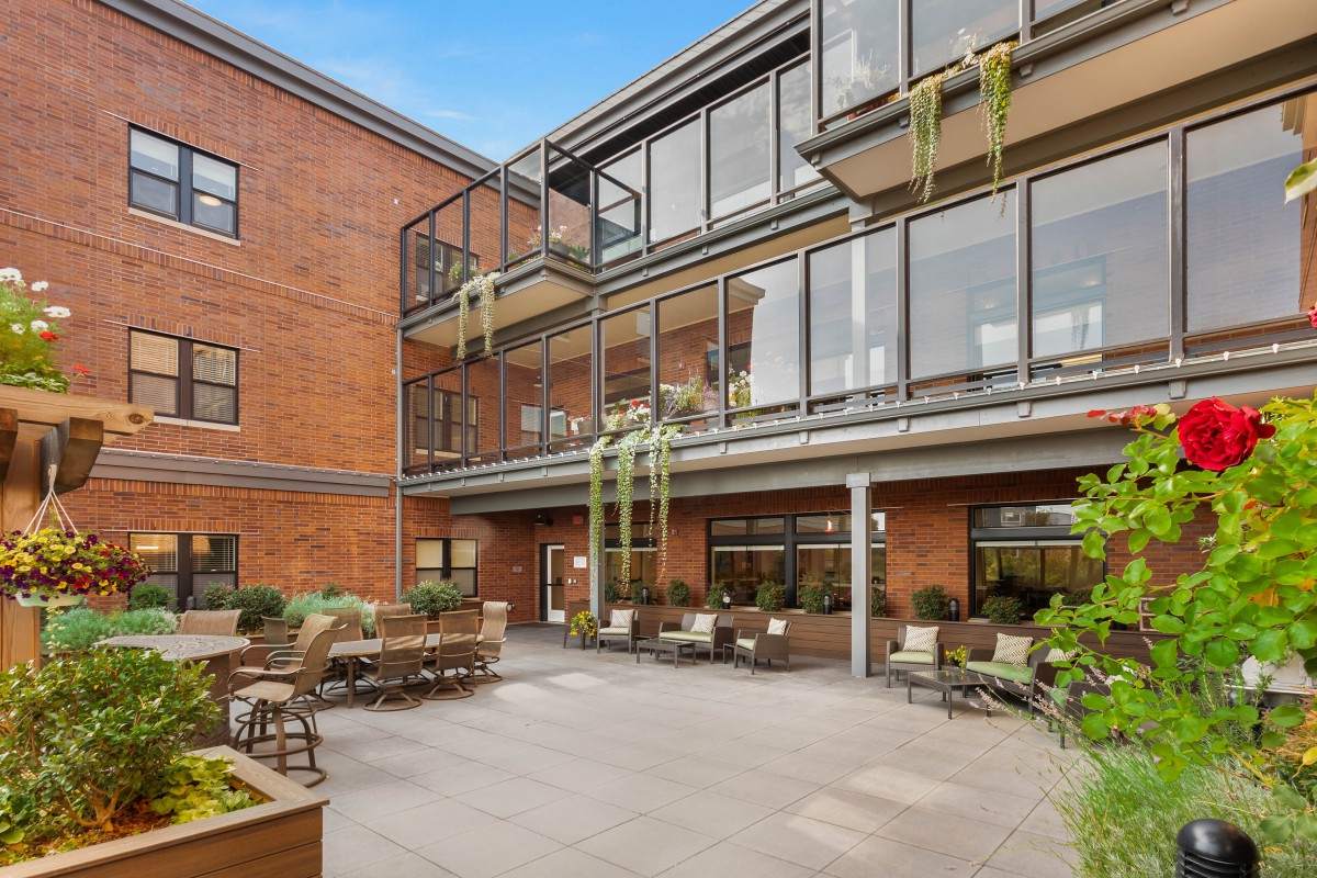 A modern apartment building courtyard with outdoor seating and balconies.