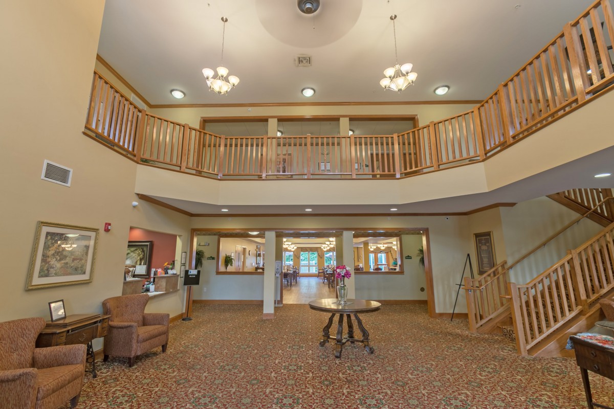 Spacious lobby with elegant lighting, wooden railings, and comfortable seating.