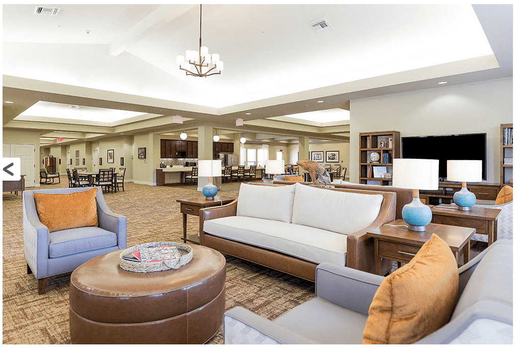 A spacious and elegantly decorated living room with modern furnishings and soft lighting.