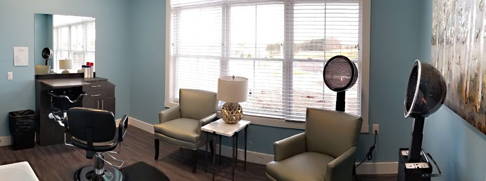 A cozy living room nook with two armchairs, a side table, and a lamp by a window.