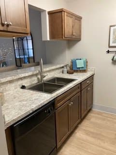 A modern kitchen with wooden cabinets and a marble countertop.