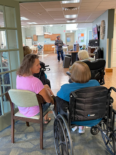 Residents engaging in conversation at a care facility.