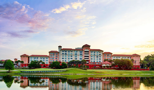 A picturesque view of a hotel by the water during sunset.