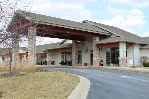 A welcoming entrance to a modern facility with a carport and landscaped surroundings.
