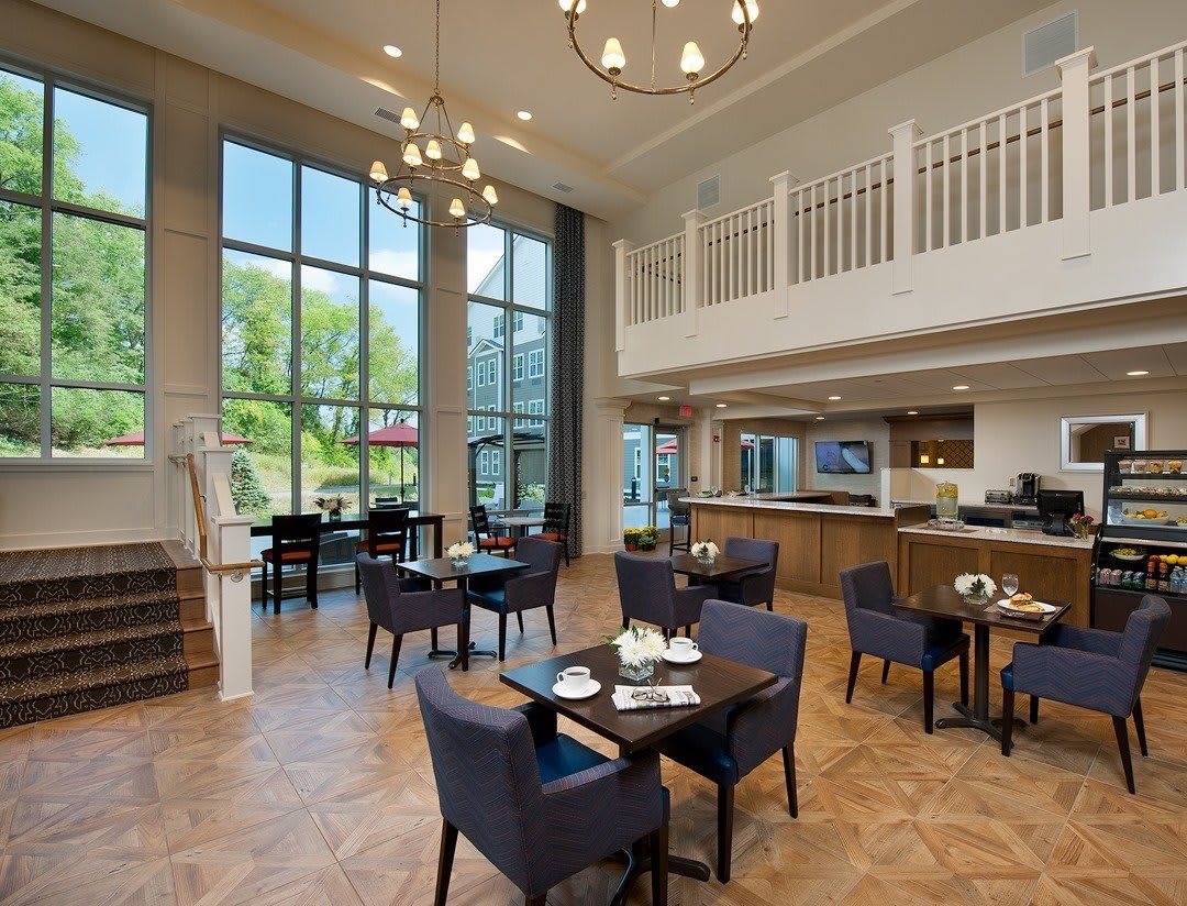 A modern restaurant dining area featuring elegant furnishings and large windows.