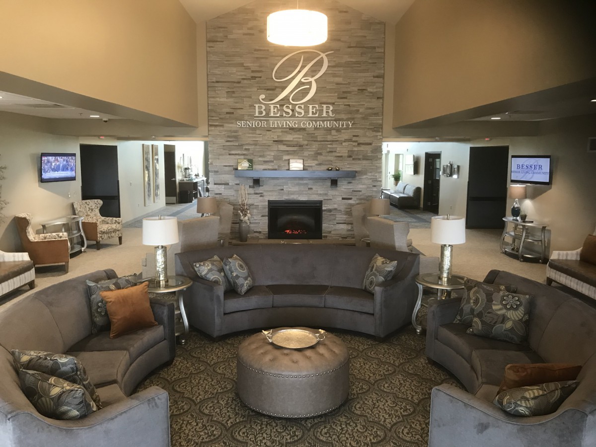 A luxurious hotel lobby featuring a cozy seating area with a central fireplace and elegant decor.