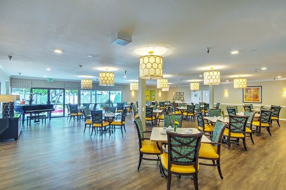 A well-lit dining area with neatly arranged tables and chairs.