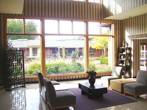 A serene and modern lounge area with large windows offering a view of lush greenery.