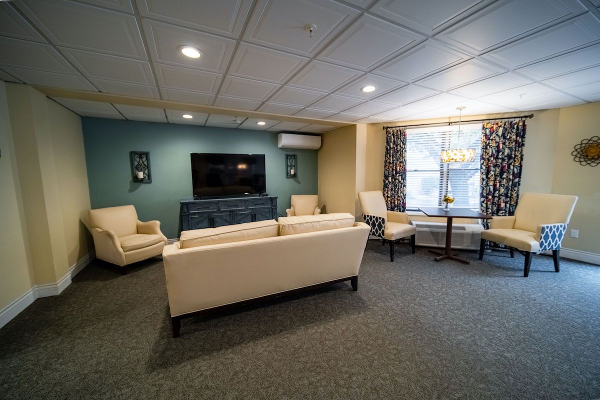 A cozy living room with modern furniture and a large television.
