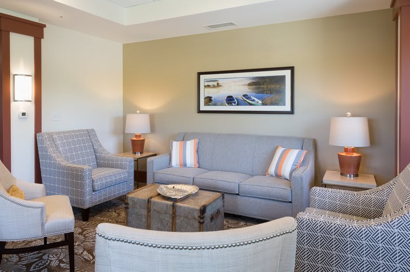 A well-appointed living room with a sofa, chairs, coffee table, and lamps.