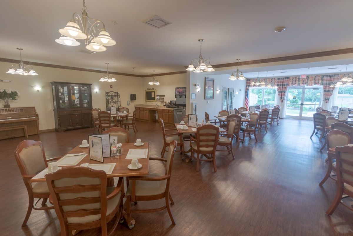 A spacious and well-lit dining area with neatly arranged tables and chairs.