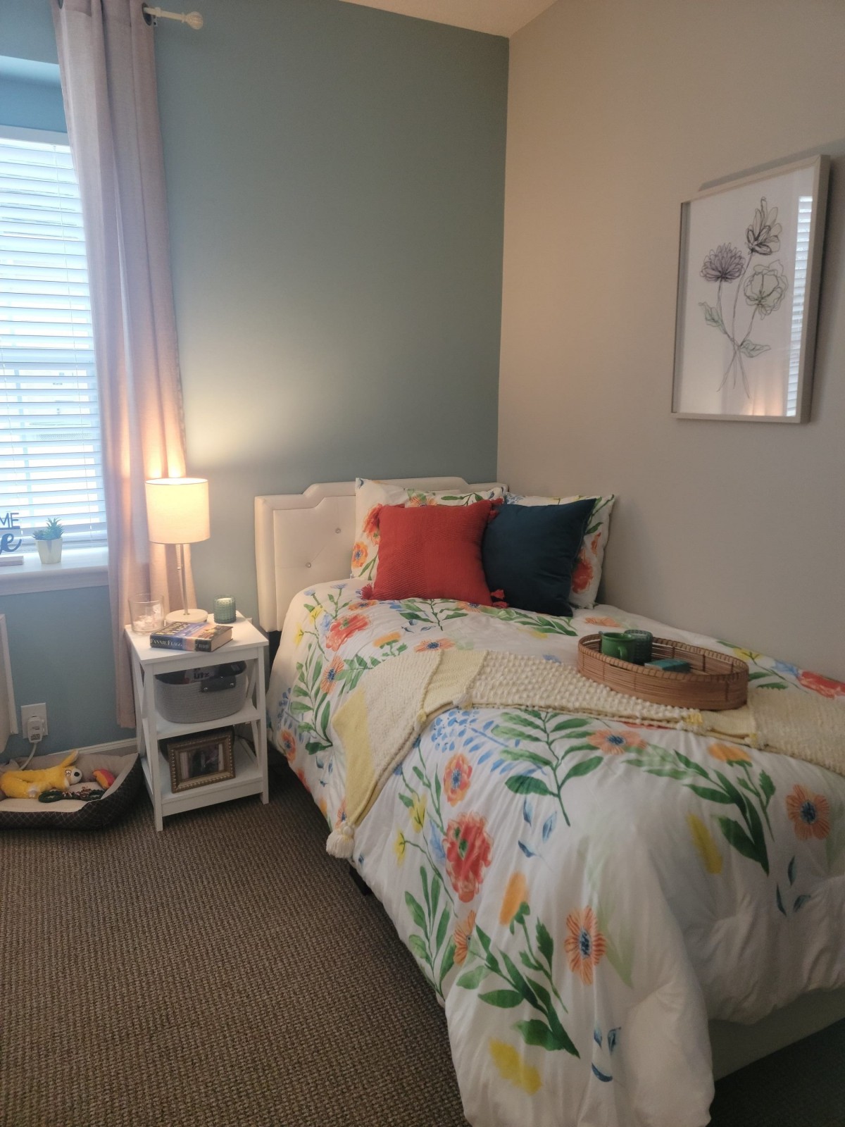A cozy bedroom featuring colorful bedding and a softly lit lamp on a nightstand.