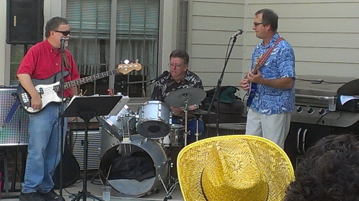 A band performing outdoors with a drummer and guitarist.