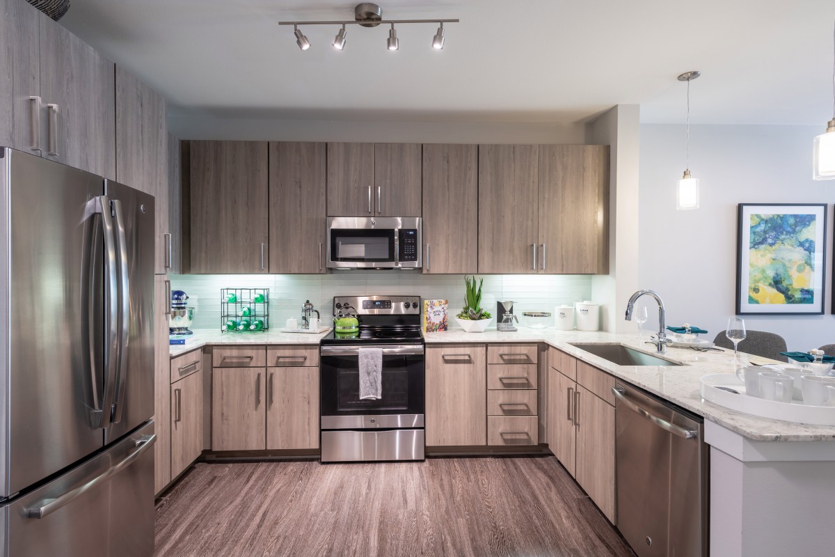 A modern kitchen with sleek appliances and wooden cabinetry.