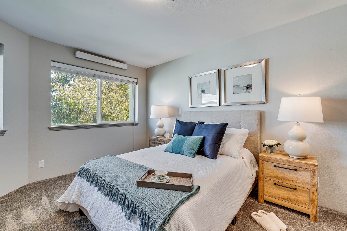 A modern bedroom with elegant decor, featuring a comfortable bed, stylish pillows, and soft lighting.