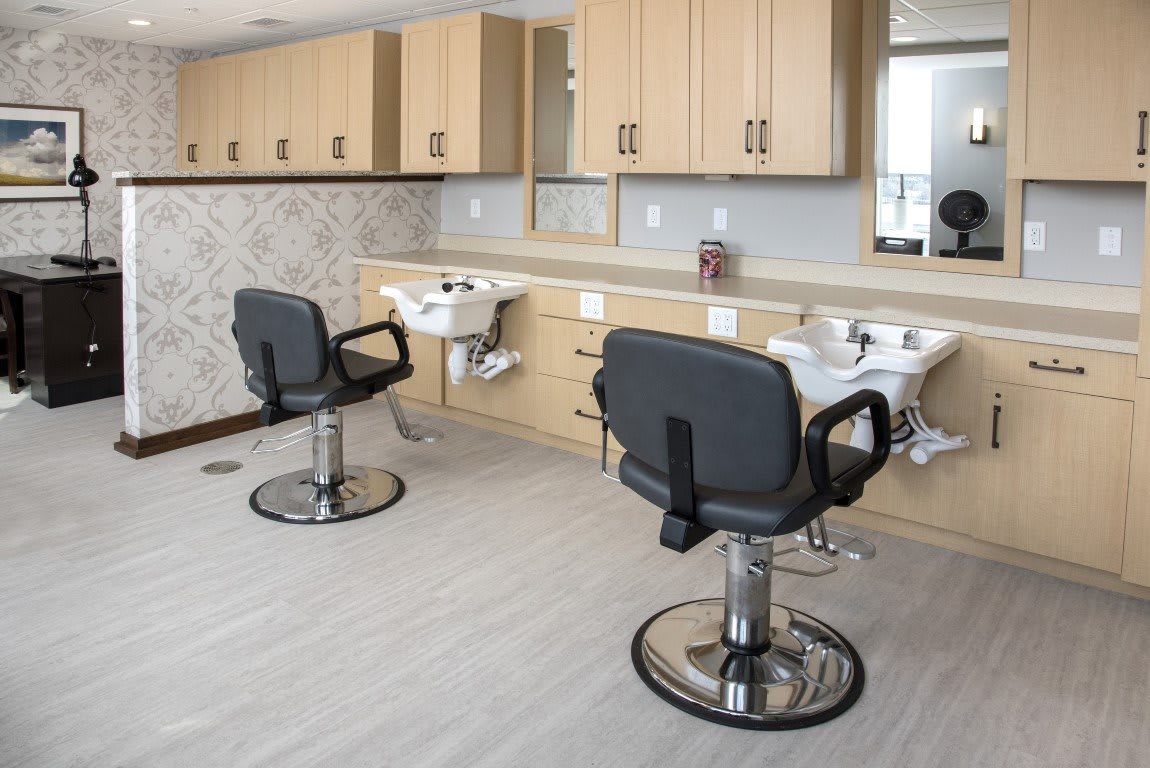 A modern barbershop interior with styling chairs and sinks.