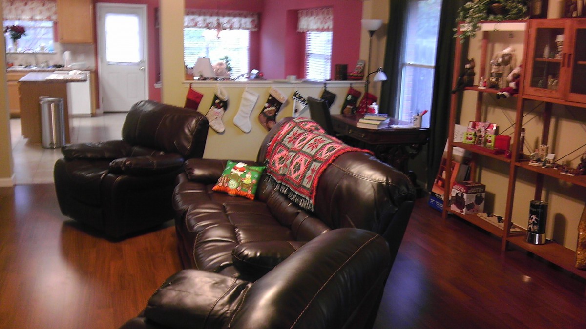 A cozy living room decorated for Christmas with stockings hung and festive pillows on the sofa.