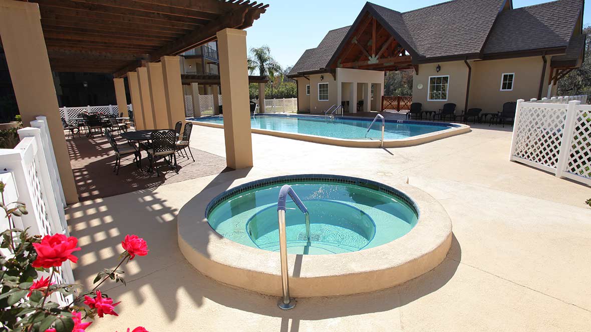 An inviting outdoor area featuring a hot tub and swimming pool under clear skies.