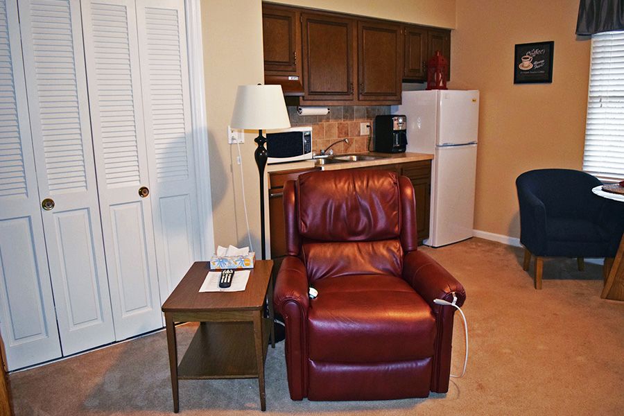 A cozy living space featuring a red recliner chair and kitchenette.
