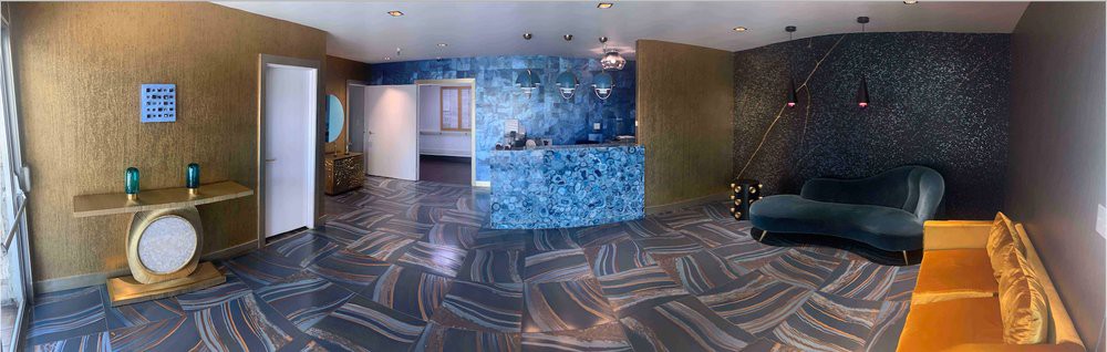 A modern reception area with a striking blue wall and abstract patterned flooring.
