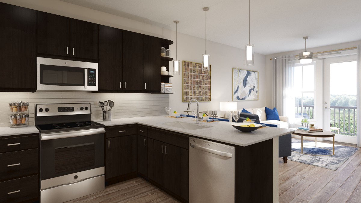 A modern kitchen featuring dark cabinets and sleek appliances, illuminated by pendant lights.