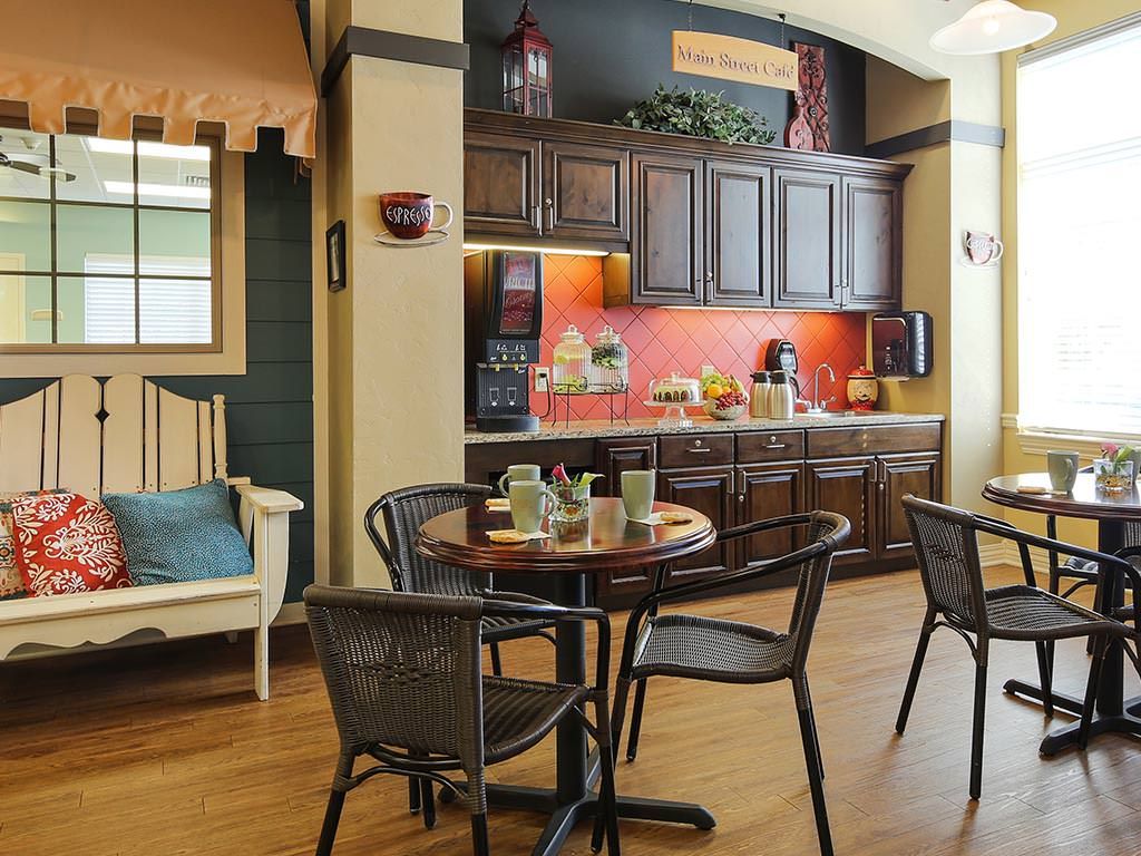 A cozy kitchen and dining area featuring wooden cabinets, a round table with chairs, and warm decor.