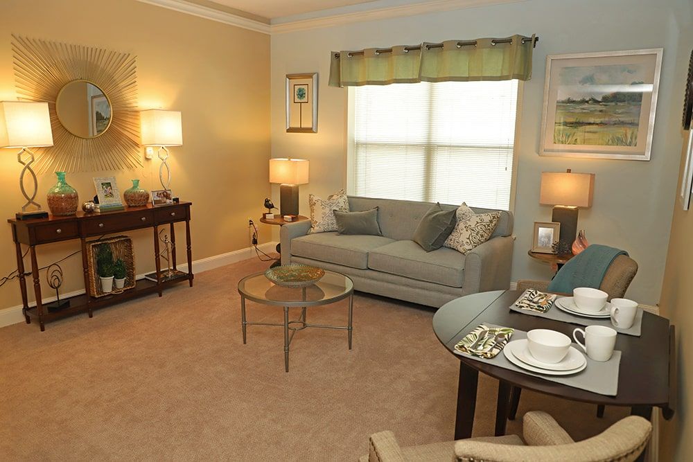 A cozy and well-decorated living room featuring a sofa, coffee table, and multiple lamps for lighting.