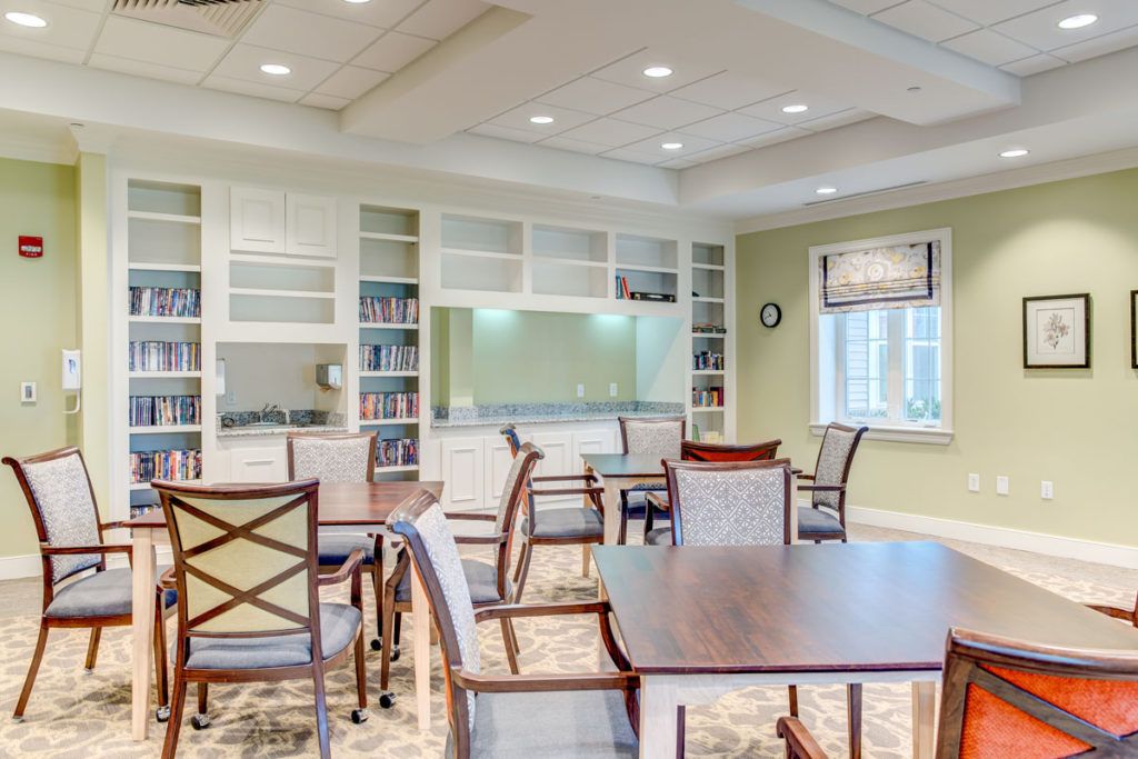 A bright and spacious dining room with tables, chairs, and built-in bookshelves.