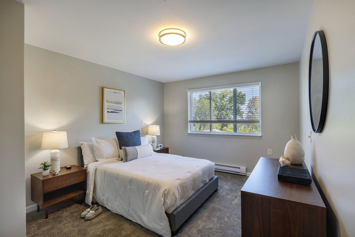 A modern bedroom with elegant decor and a large window.