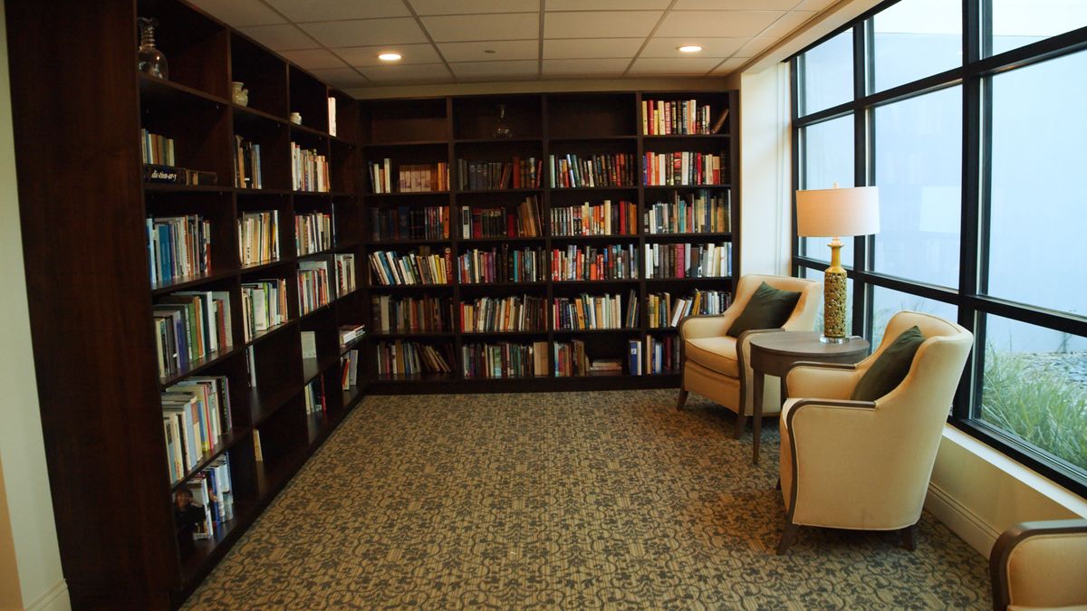 A cozy reading nook in a library with bookshelves and comfortable armchairs.