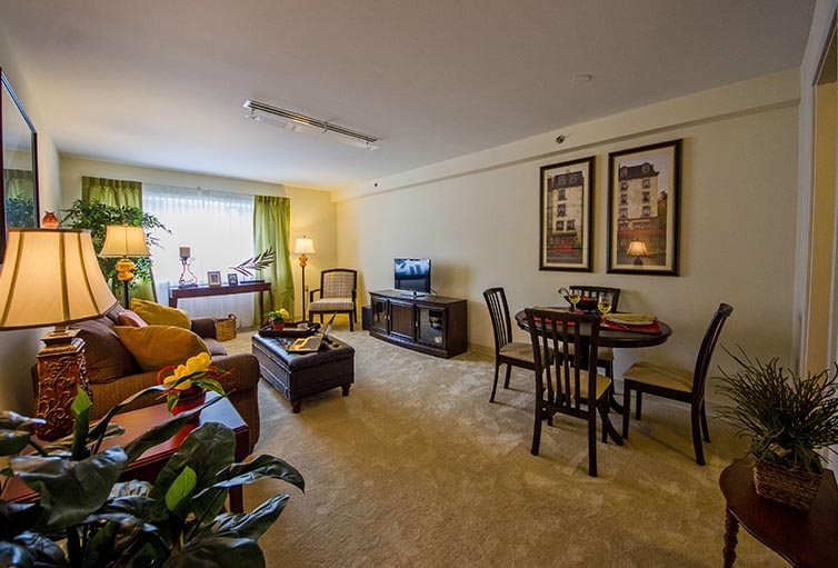 Cozy living room with a dining area, featuring comfortable furniture and warm lighting.