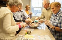 A group of seniors engaged in a cooking activity together.