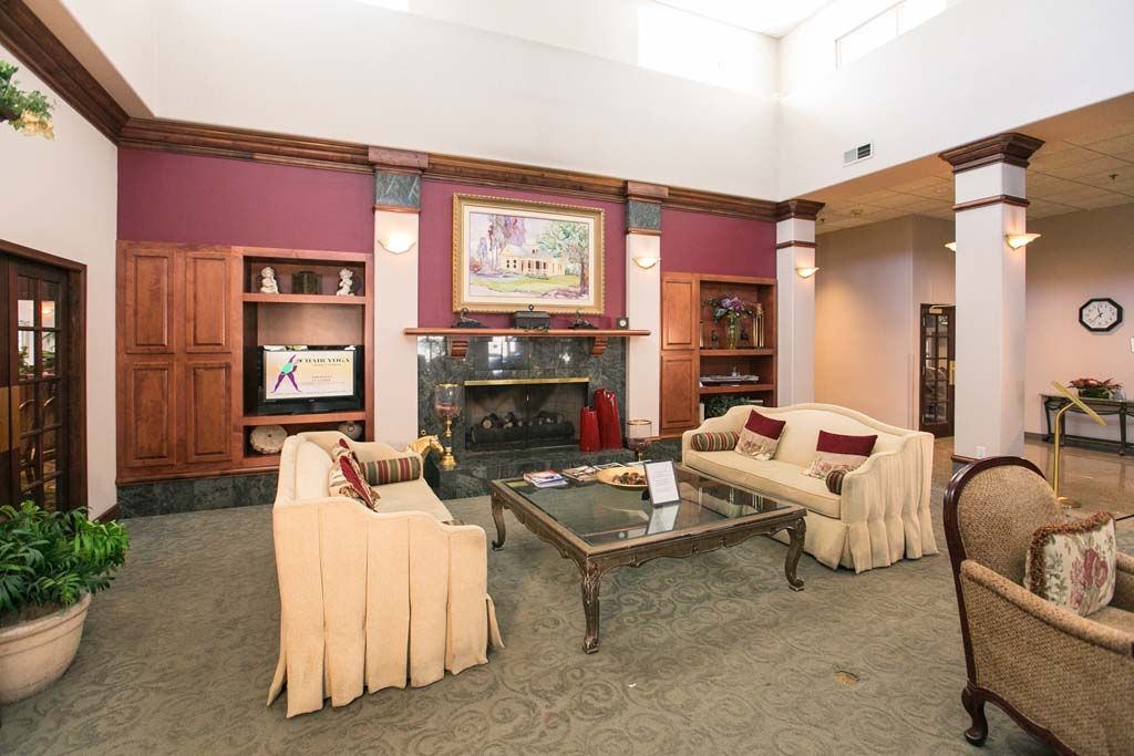 A cozy living room with two sofas, a coffee table, and a fireplace adorned with artwork.