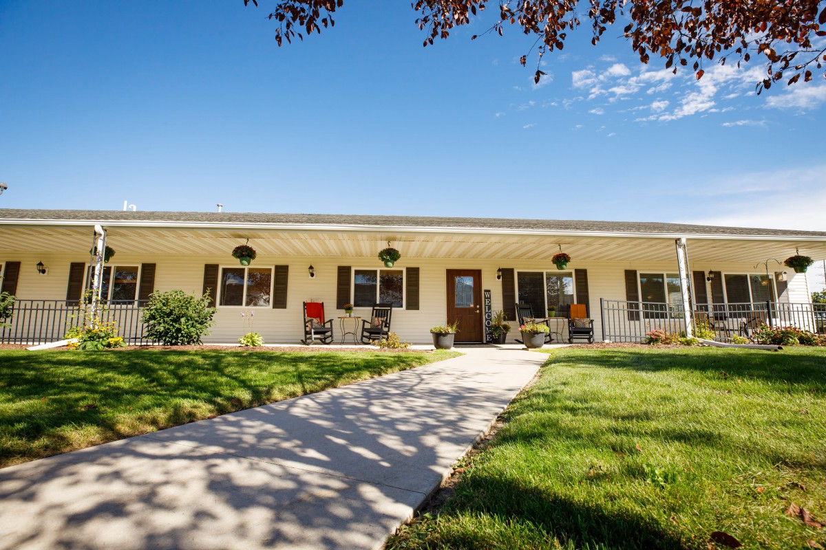 A charming single-story house with a neatly maintained front yard and pathway on a sunny day.