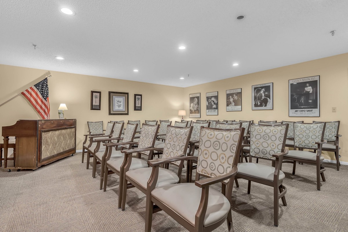 An empty conference room with neatly arranged chairs and decorative paintings on the walls.