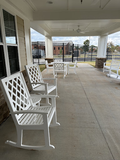 A serene outdoor porch featuring white chairs, perfect for relaxation.