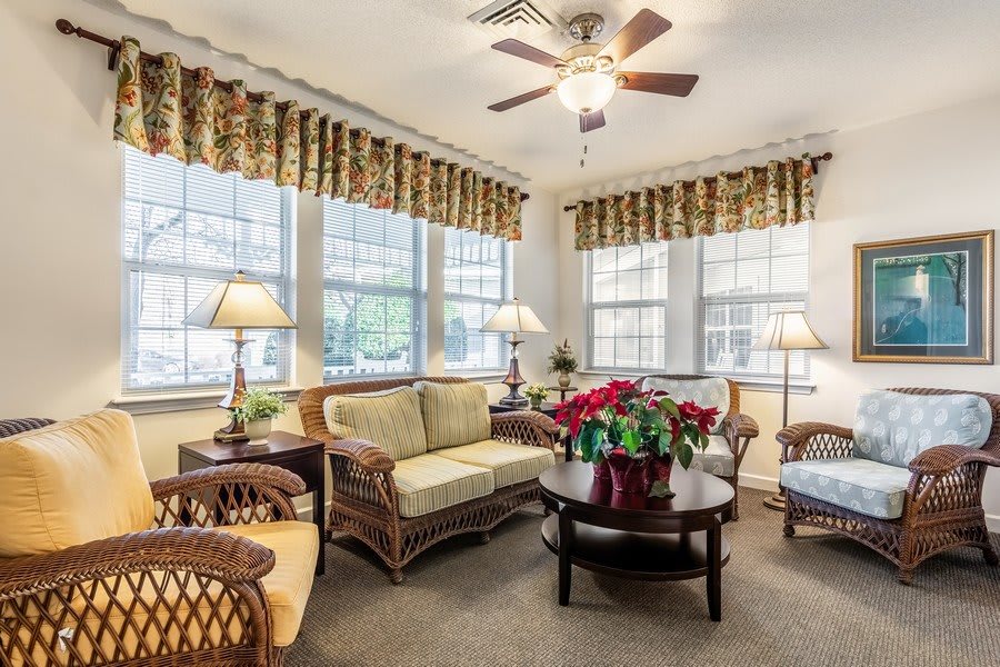 A cozy living room with wicker furniture and large windows showcasing elegant decor.