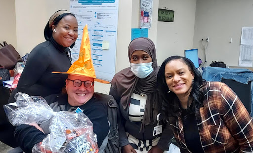 A joyful celebration with friends, showcasing festive hats and smiles in an office environment.
