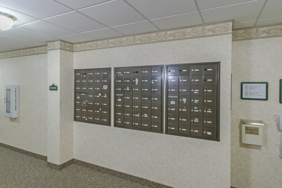 Wall-mounted mailboxes in an apartment building hallway.