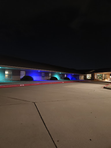 A modern building illuminated with colorful lights at night.