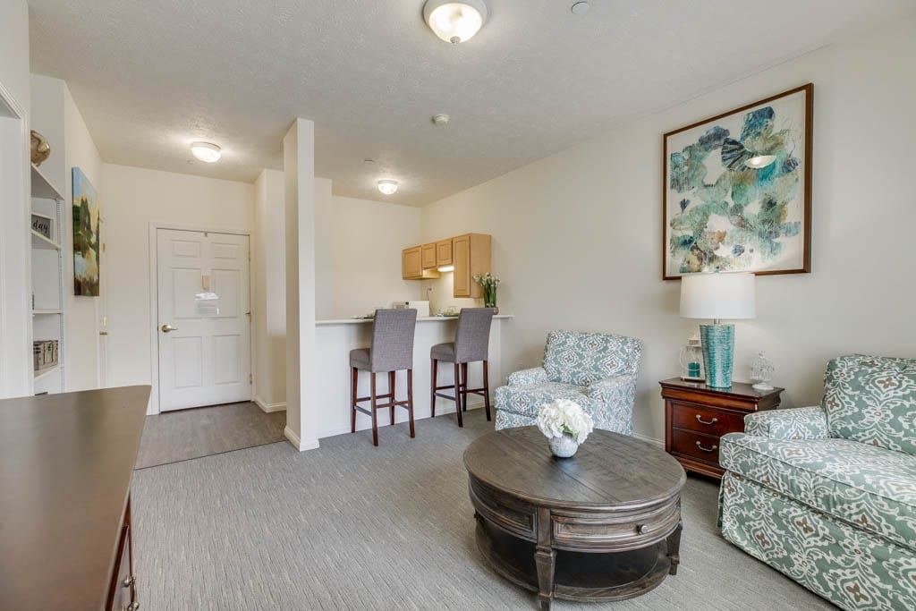 A cozy living room with elegant furniture and a small kitchen area.