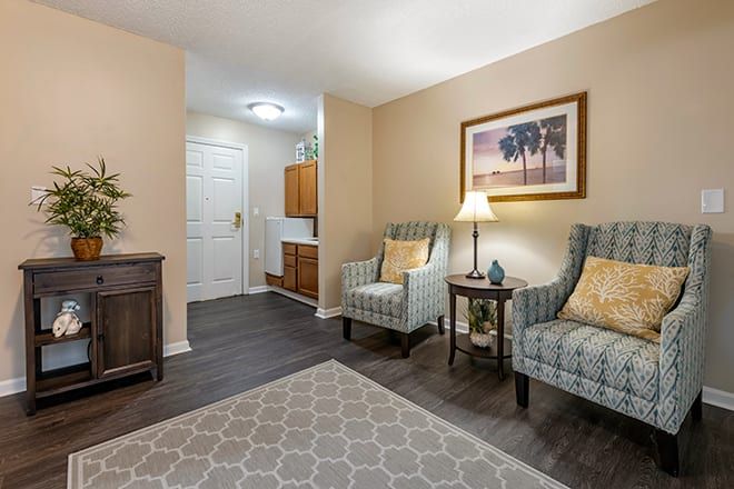 A cozy living area with two armchairs, a lamp, and wall art creating a welcoming atmosphere.