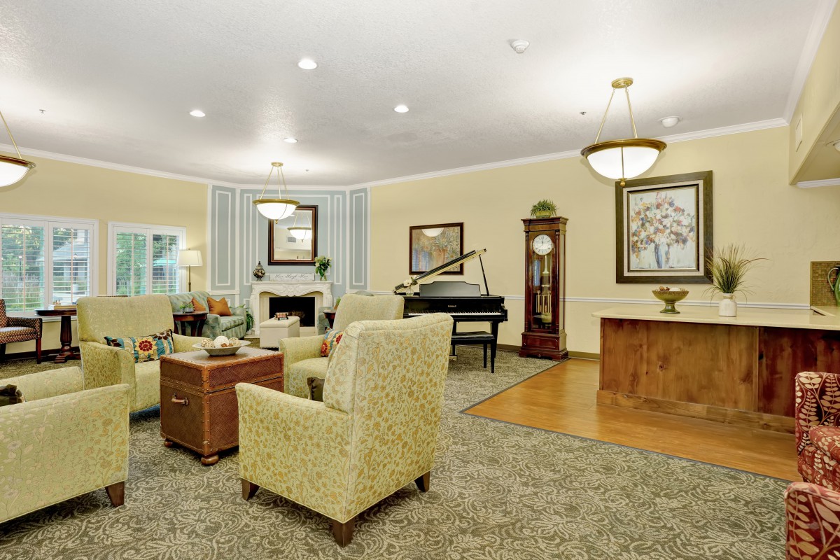 A cozy and elegantly decorated living room with comfortable seating and a grand piano.