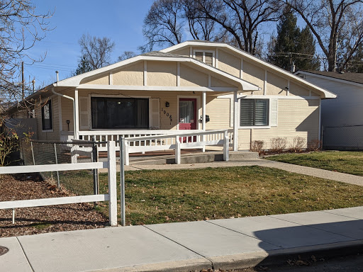 A charming single-story house with a welcoming porch and well-maintained front yard.