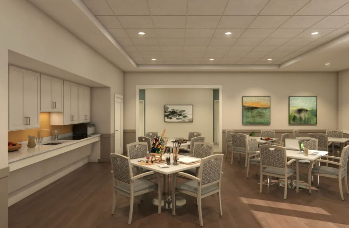 A modern dining room with neatly arranged tables and chairs, decorated with artwork on the walls.