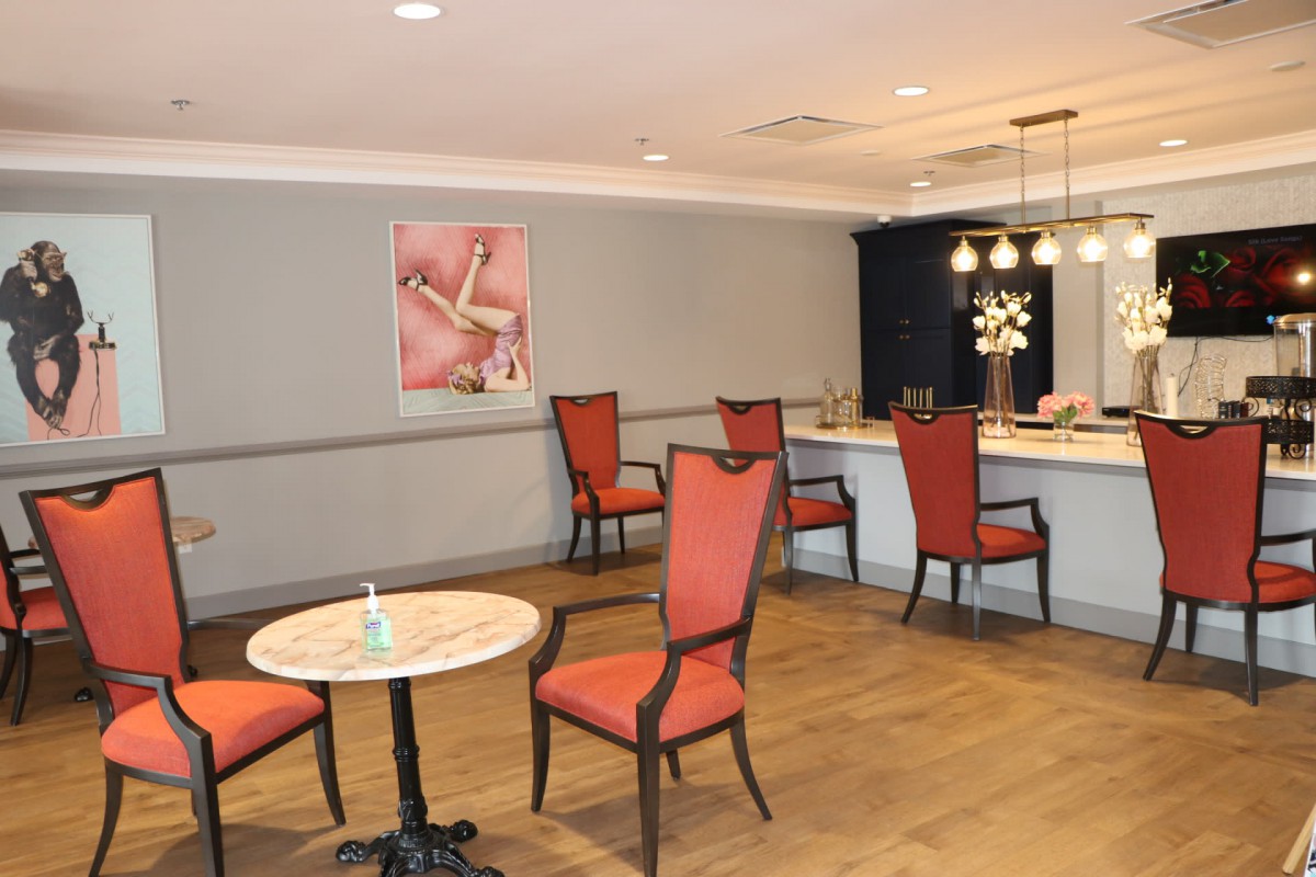 A cozy lounge area with red chairs and a small bar.