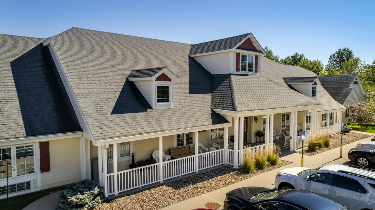 A suburban house with a large porch and dormer windows.
