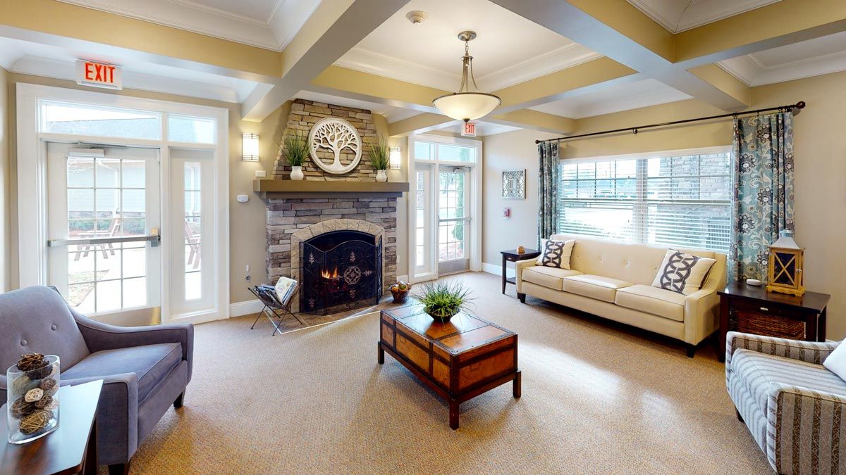A cozy and modern living room featuring a stone fireplace, comfortable seating, and elegant decor.