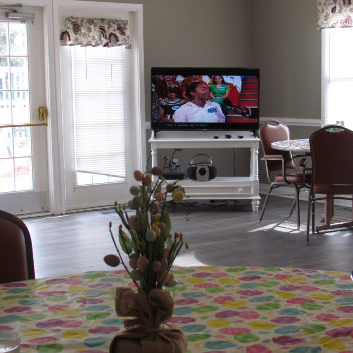 A cozy living room with a television and dining area.